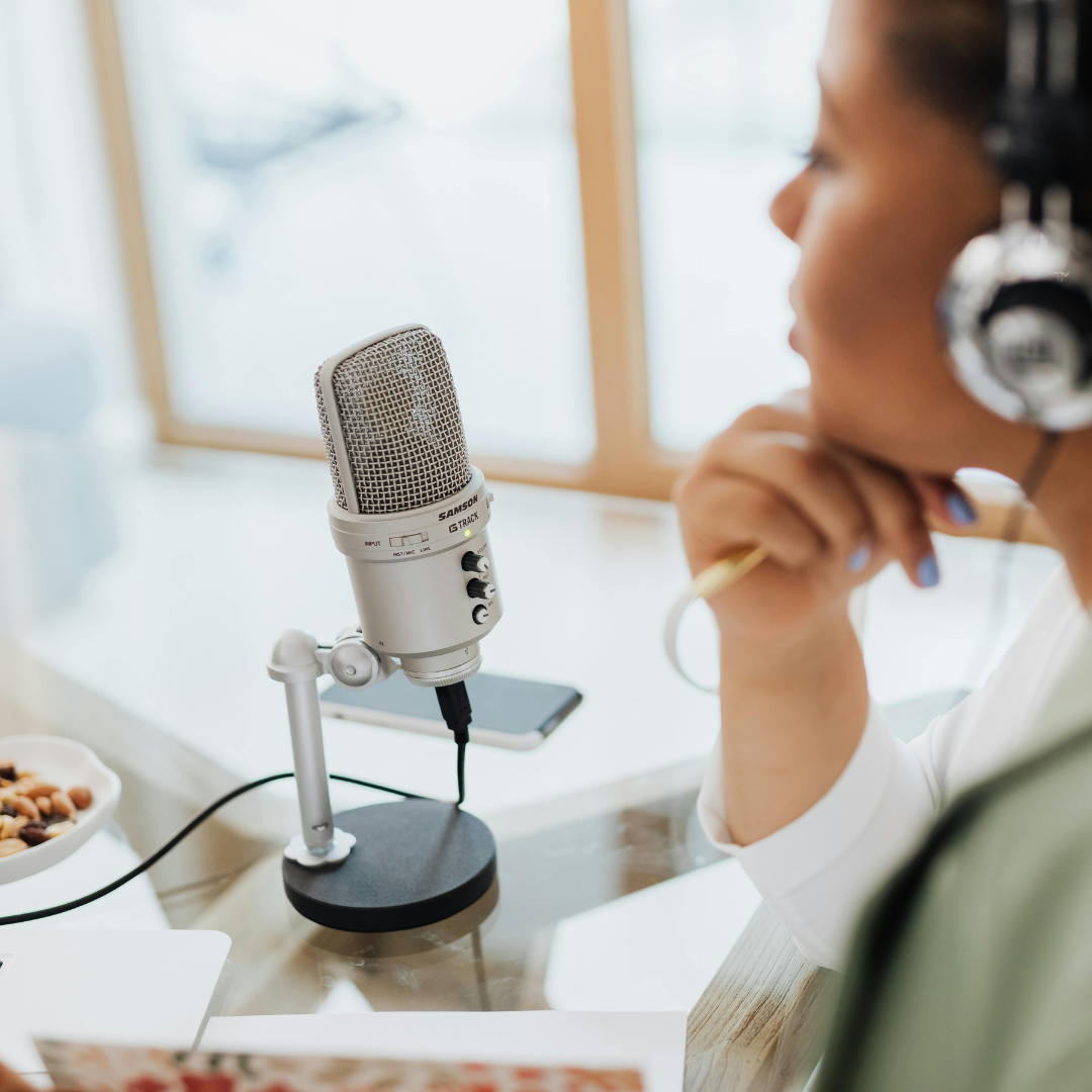 • brainstorming podcast name ideas • entrepreneur planning podcast branding • woman choosing podcast title at desk • podcast planning notebook and microphone