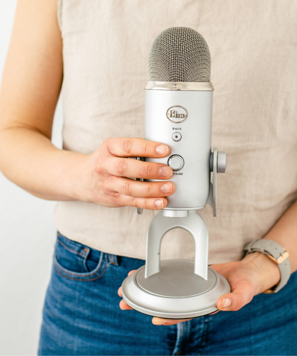 • entrepreneur recording podcast at home desk • simple podcast setup with laptop and microphone • beginner podcast recording space • small home office podcast setup