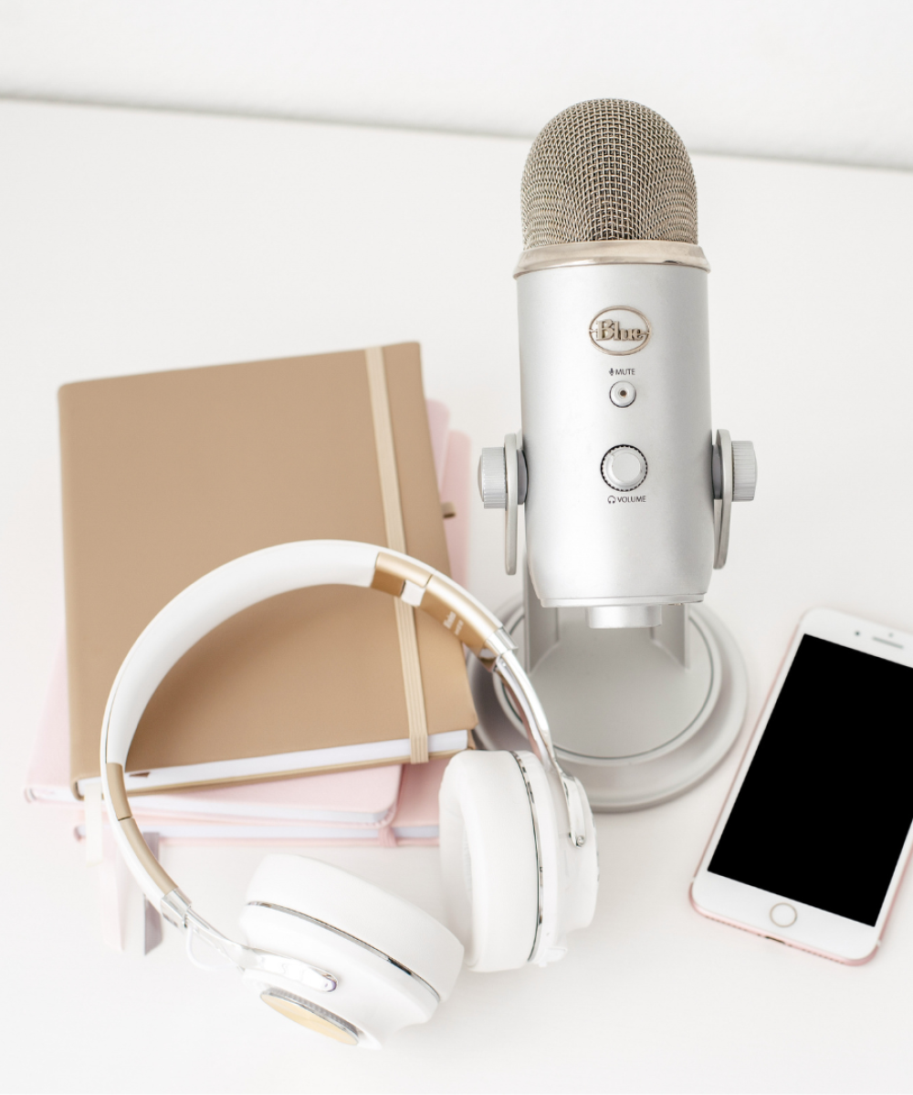 • planning podcast content calendar • entrepreneur scheduling podcast episodes • podcast planning notebook and calendar • content planning workspace with microphone